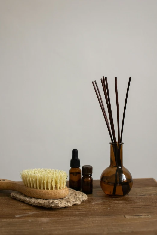 a couple of wooden brushes sitting next to bottles on a table