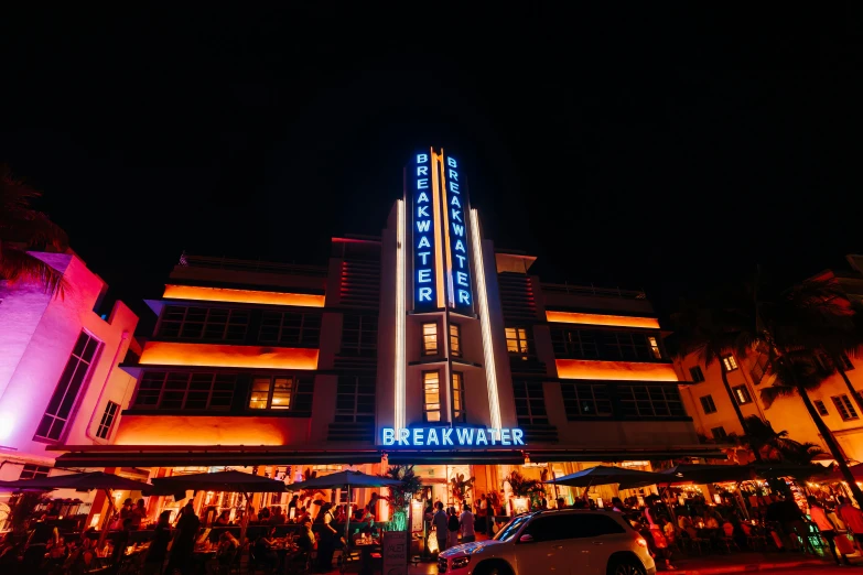 people standing on a street in front of an elaborately decorated el at night