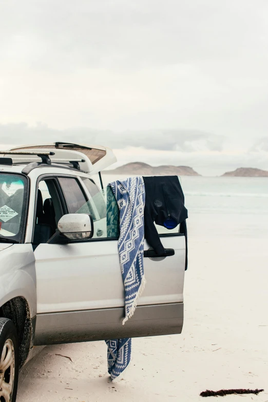 a truck with its hood up parked on a beach