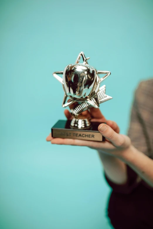 the woman is holding up a silver award