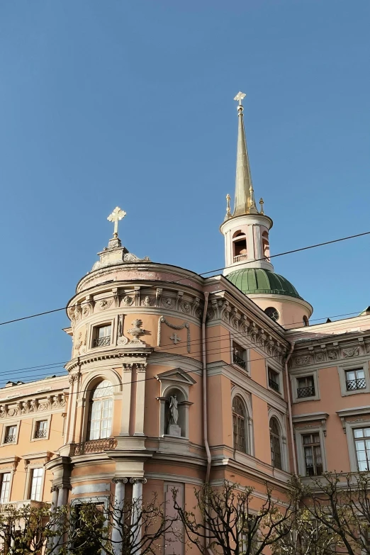 a big pink building with a tall steeple on top