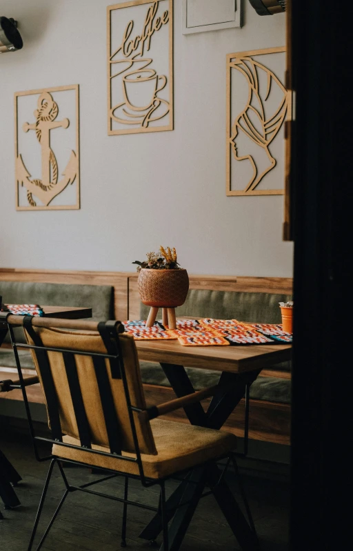 an empty dining table sitting in front of framed pictures