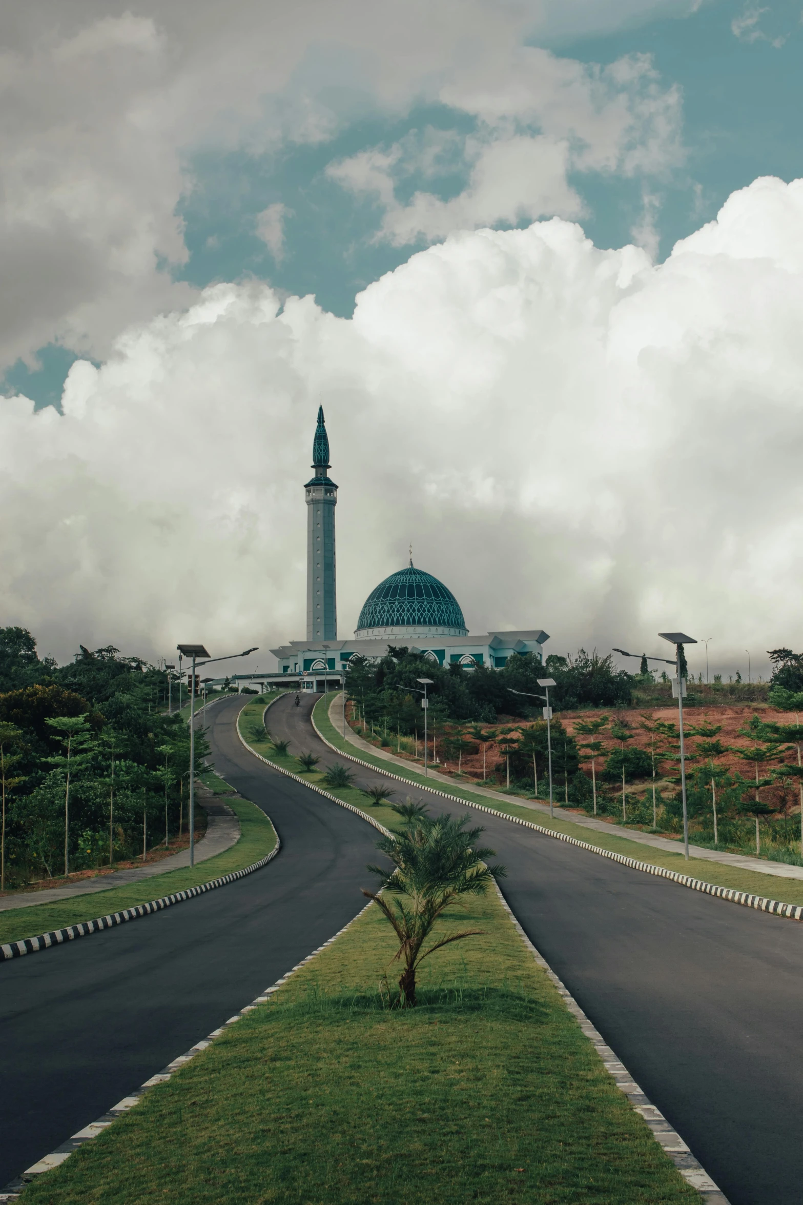 a long road that leads to a mosque on top of it