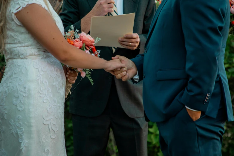 man and woman in wedding attire with flowers