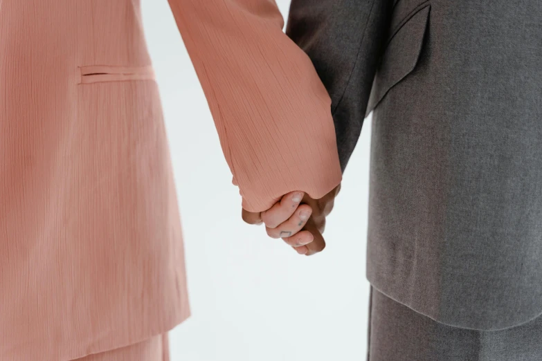 two people hold hands as they walk