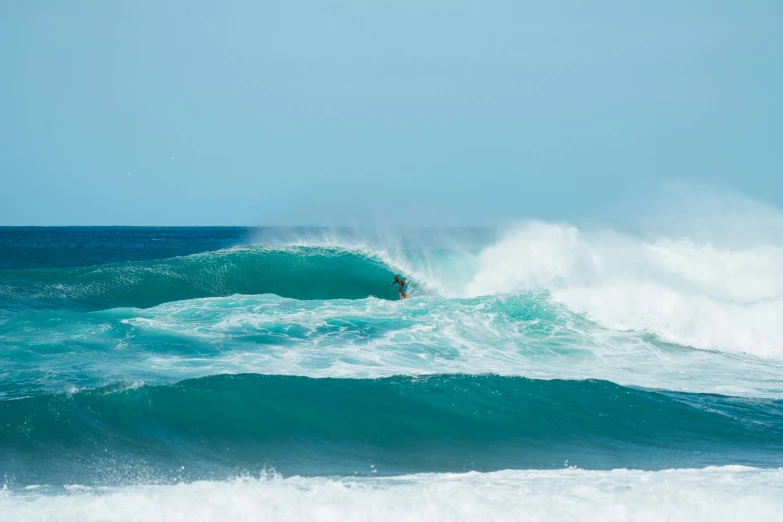 a person riding a surfboard on top of a wave