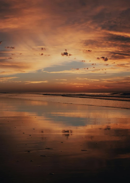 an orange sky at the beach during sunset