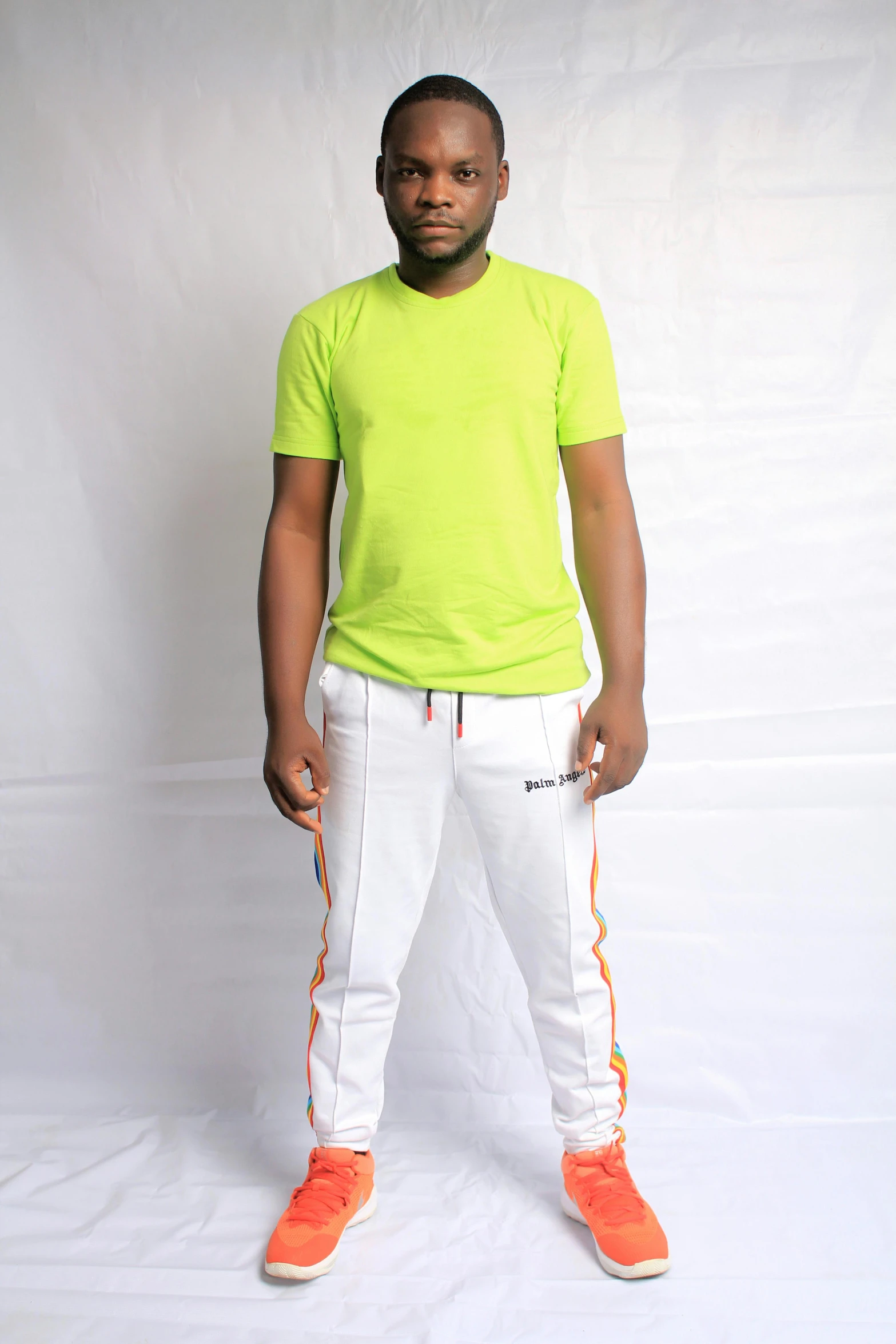 a man in a yellow shirt and white pants