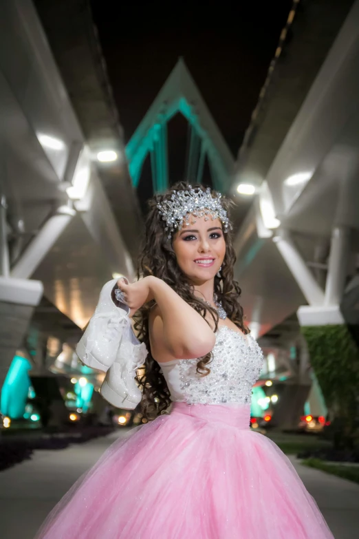 a lady in a dress standing under a bridge