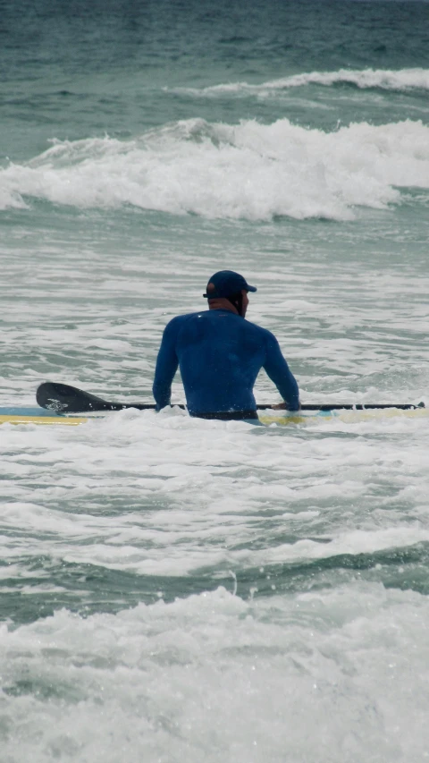 a man in blue is on his surfboard out on the ocean