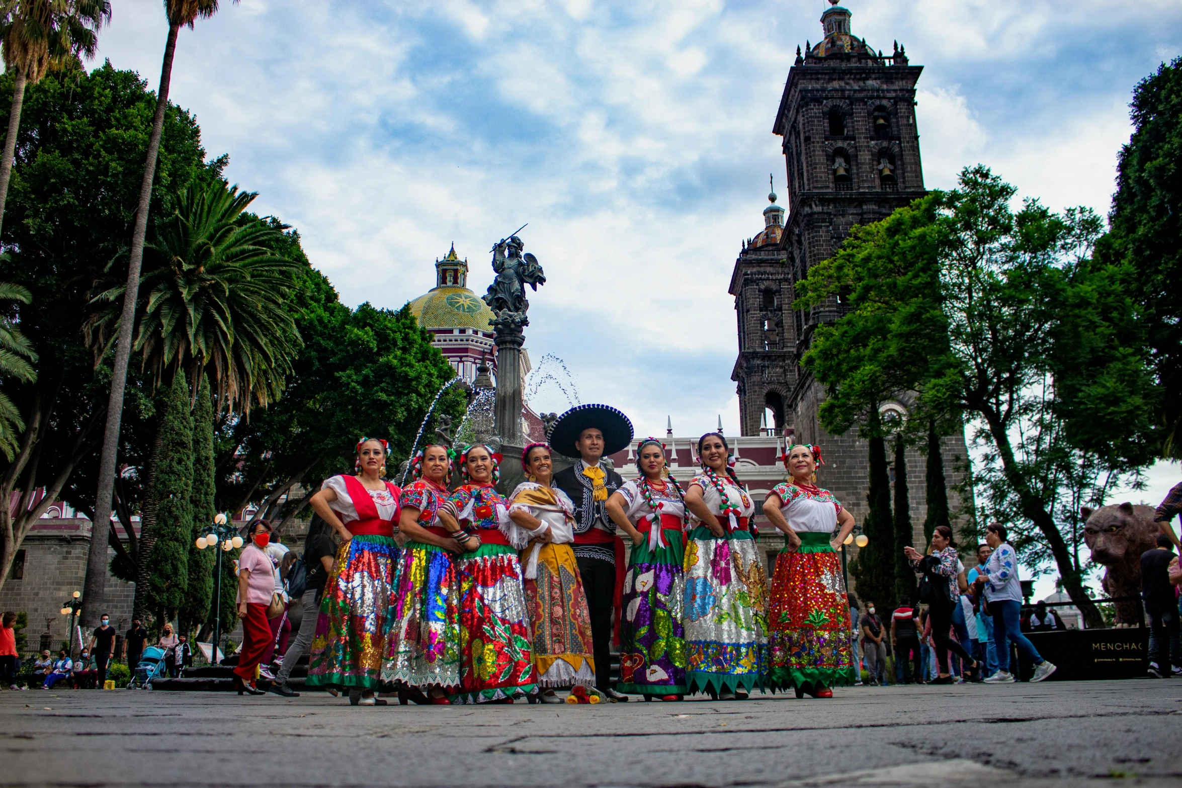 a woman with an elaborate skirt and a group of people standing near her