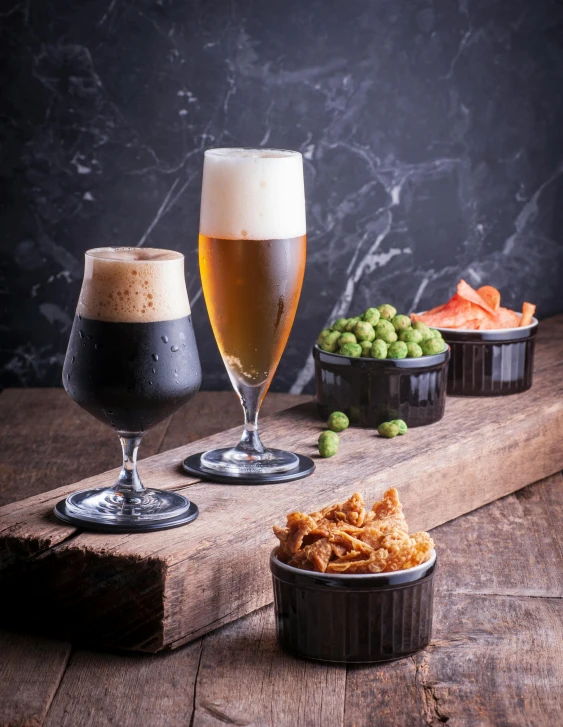 a close up of two glasses of beer on a table