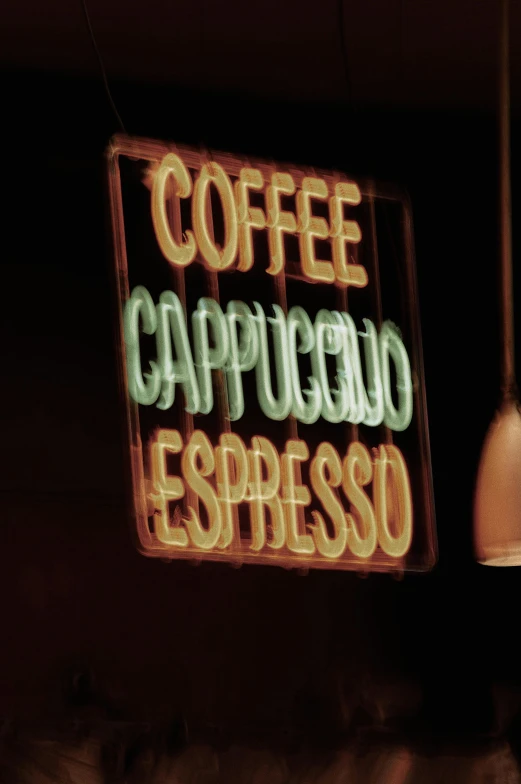 a sign reading coffee cappuccino espresso with a light bulb hanging