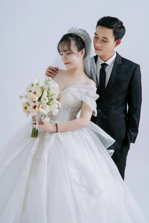 an asian man and woman pose for a wedding picture
