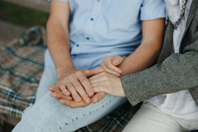 the people's hands are placed on the couple's leg