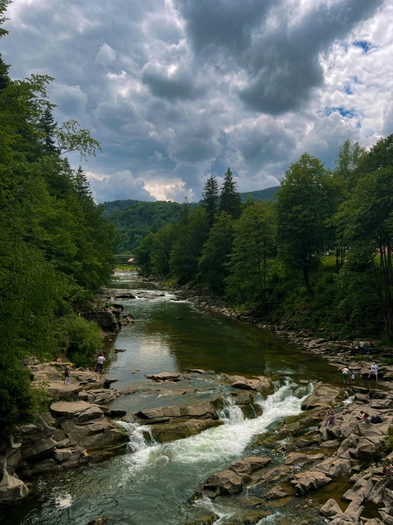 a stream is flowing between the rocky banks