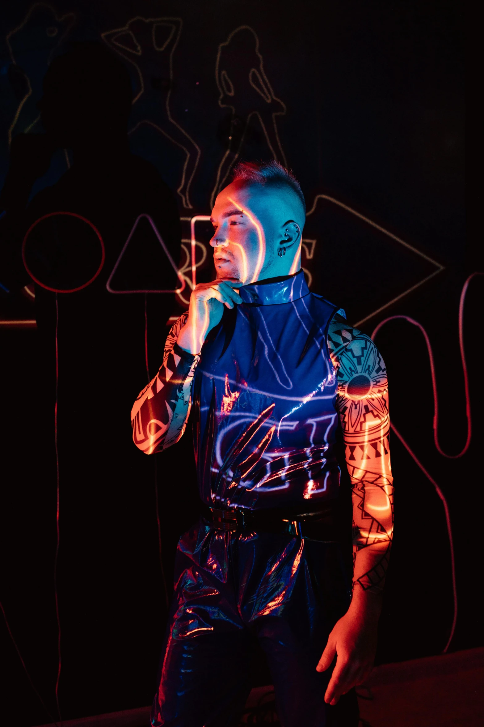 man wearing colorful light painting while singing into a microphone