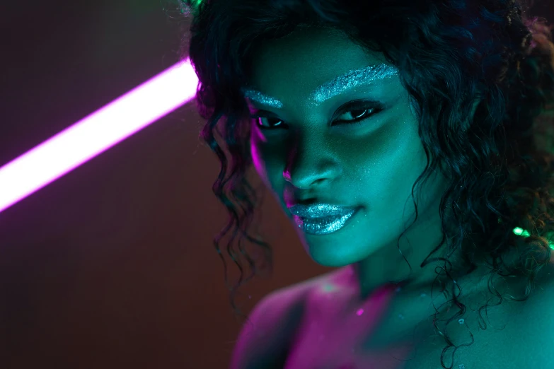 an african american girl wearing face paint and holding a neon saber