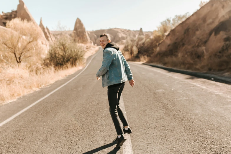 a man standing on a road in the desert