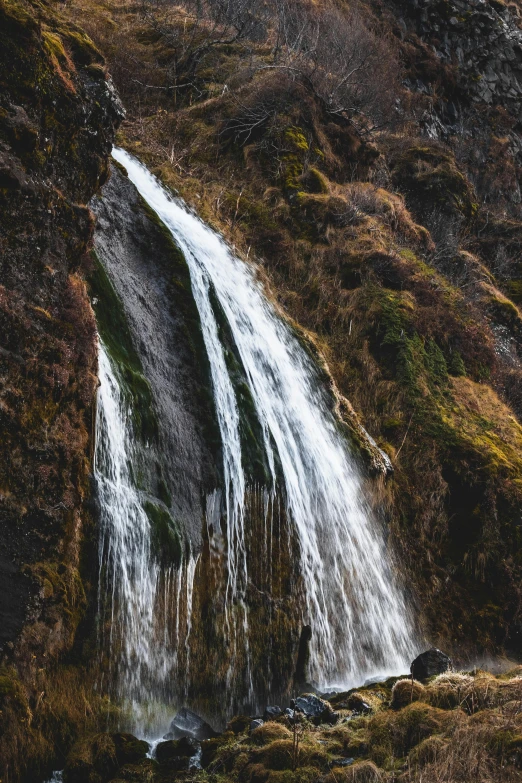 a small waterfall is shown on the side of the mountain