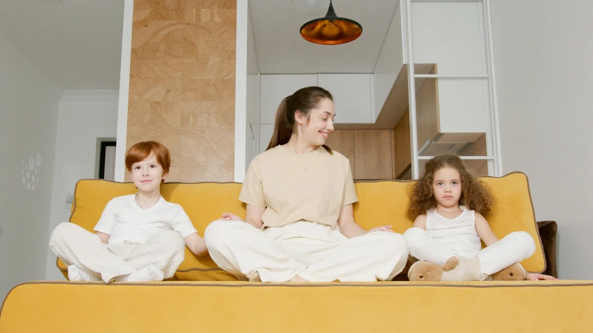 a woman and two children sitting on top of a couch