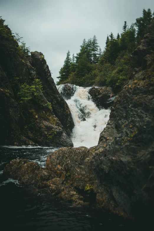 there is a large waterfall surrounded by rocks