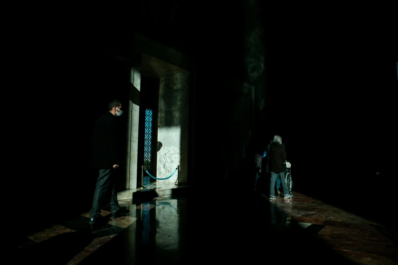 a man and woman are standing in a dark hallway