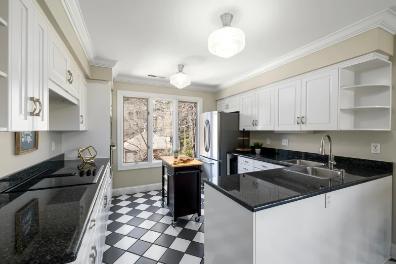 a clean kitchen is painted white and features black countertops