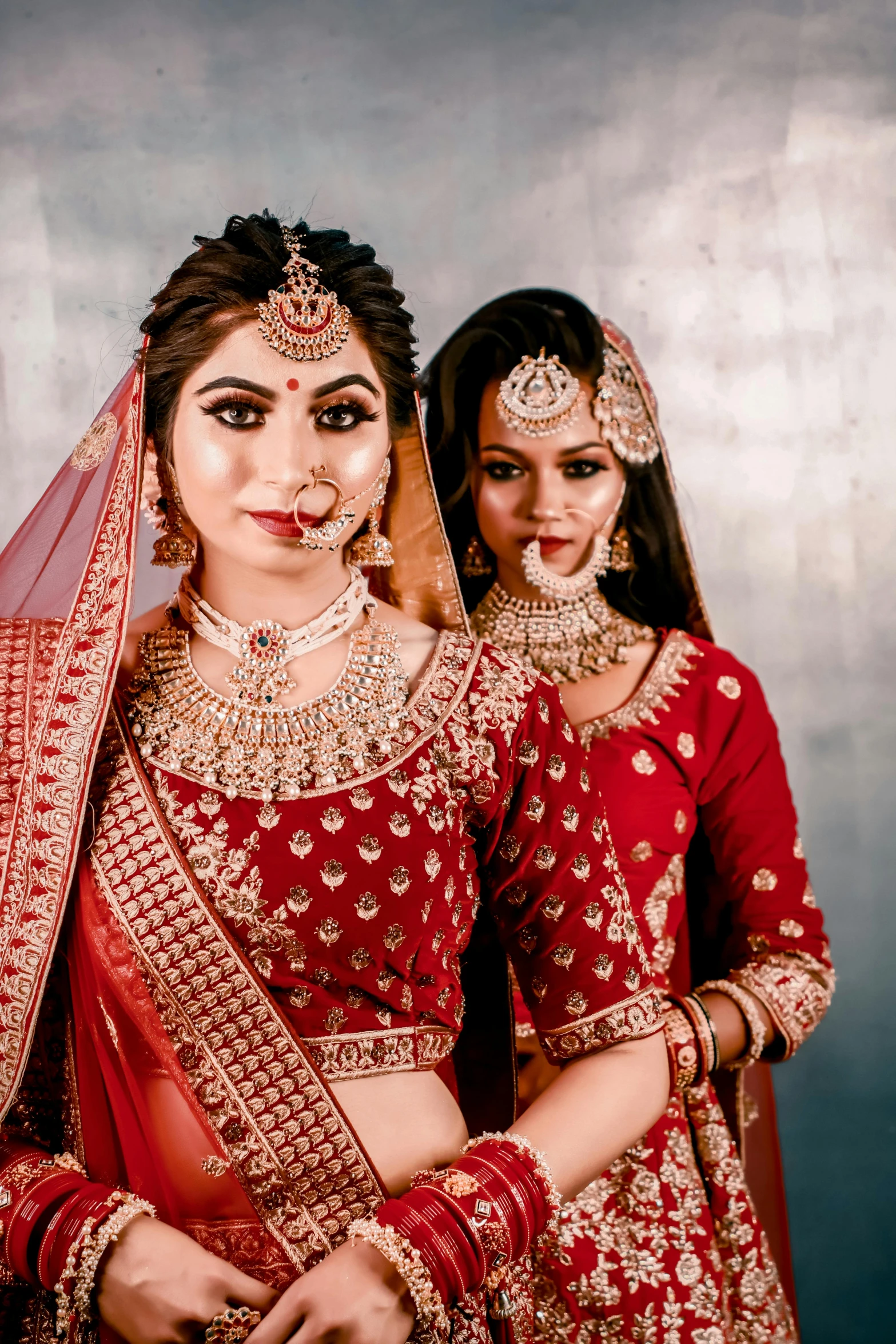 two woman dressed in indian costumes are posing for the camera