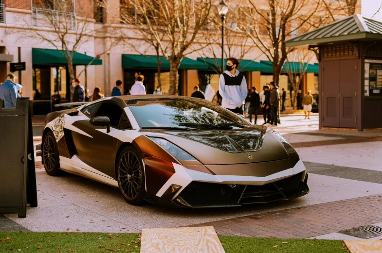 the gray sports car is parked on the street