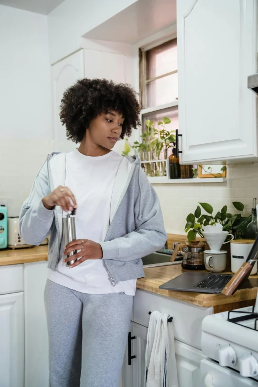 a woman holding onto an empty can in the kitchen