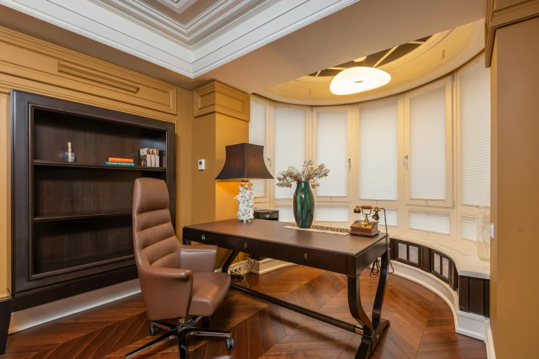 an office with a leather desk, chair and bookshelf