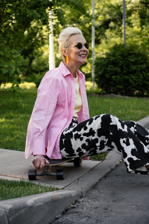 an elderly lady is riding a skateboard down the curb