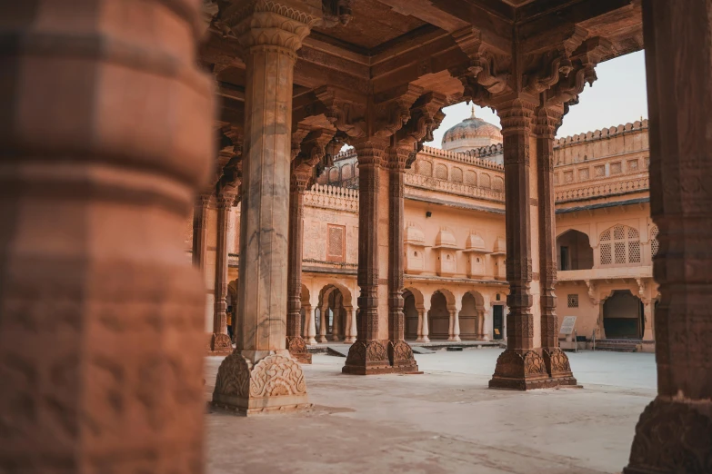 the pillars of an old building, with the clock in front