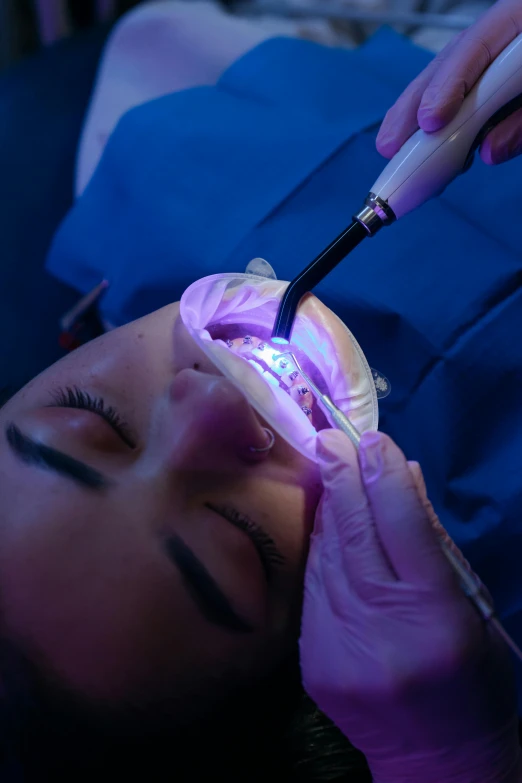 a woman laying down in the dental chair getting her teeth checked