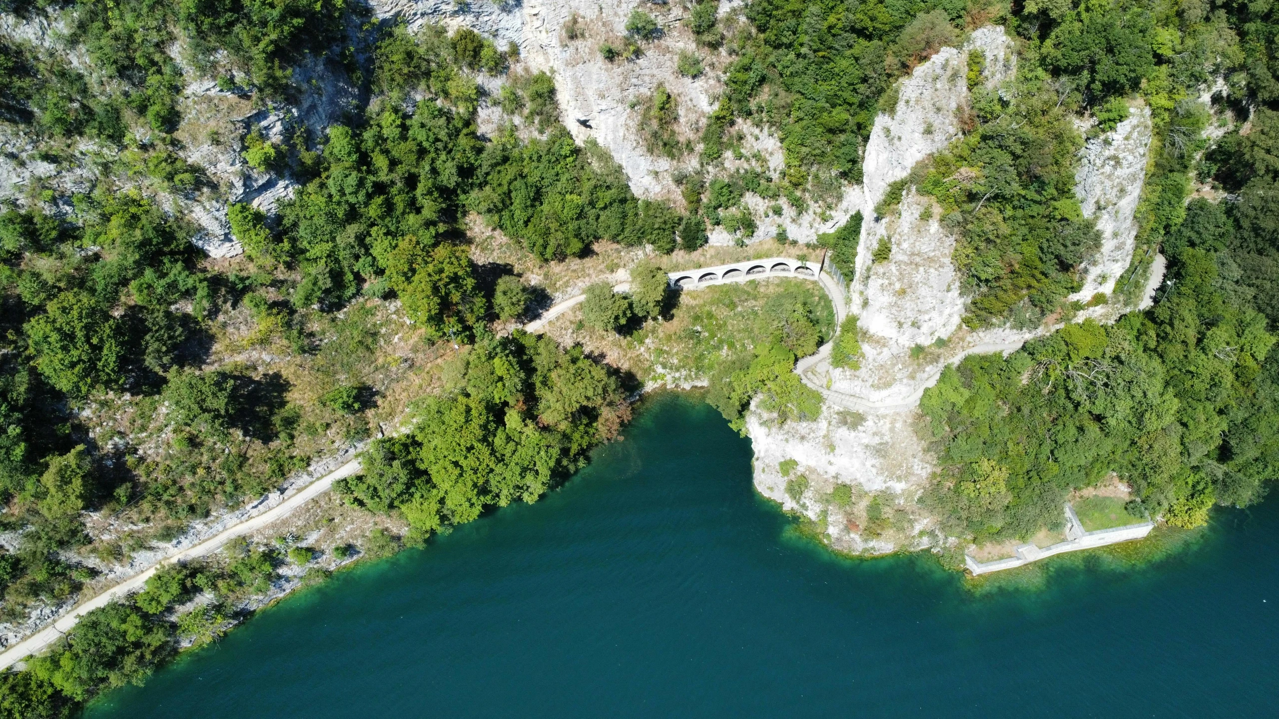 an aerial view of a river with trees in the background