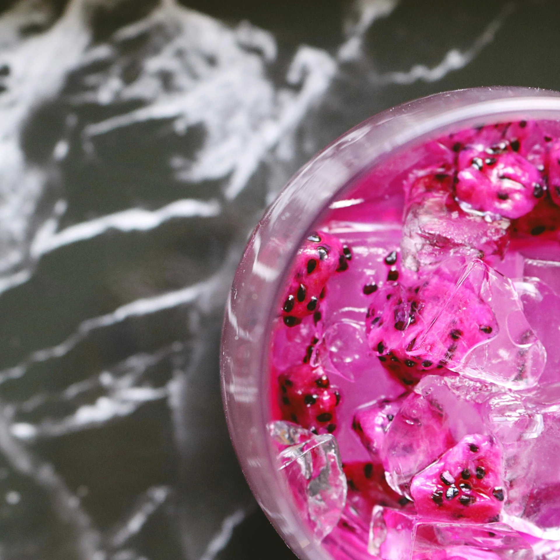 a pink drink is in the glass on the table