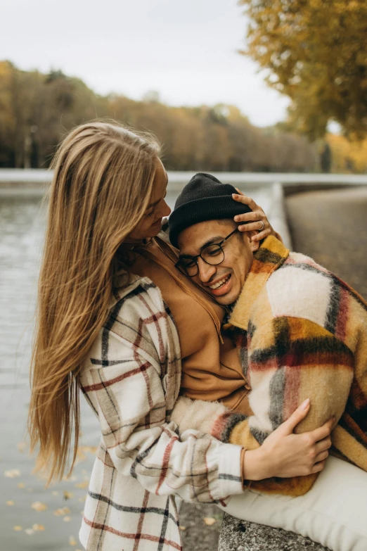 two woman hugging with their dogs, while smiling