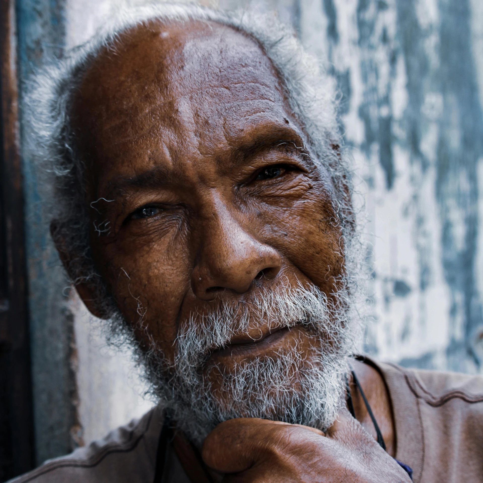 an old man has gray hair and is posing for the camera