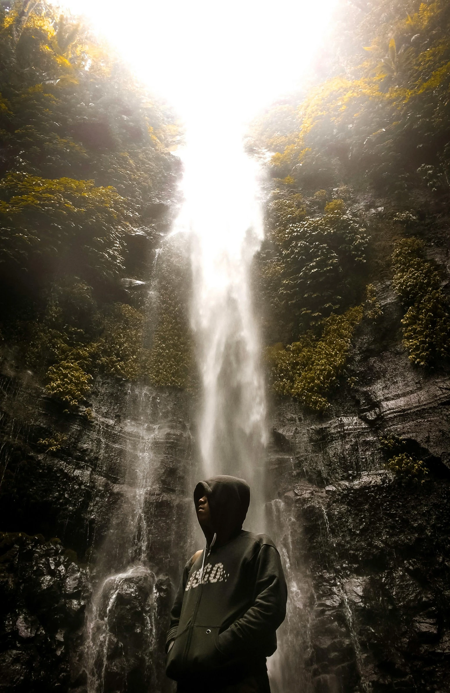 a person standing in front of a waterfall