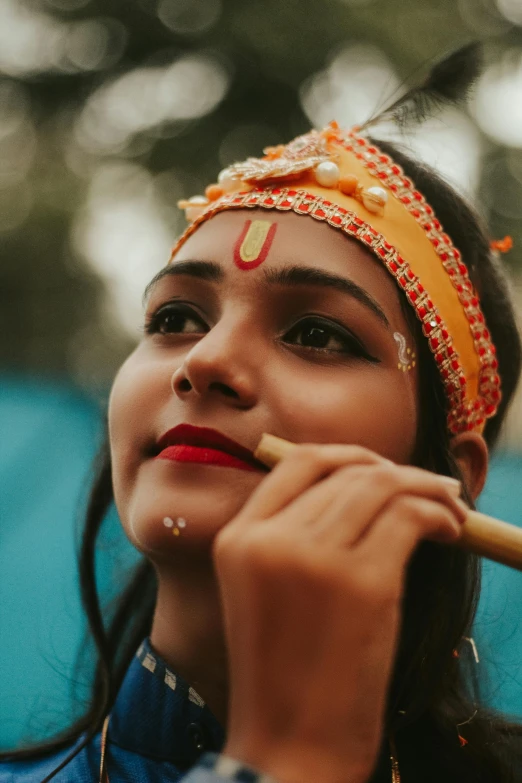 a woman is brushing her teeth with a bamboo stick