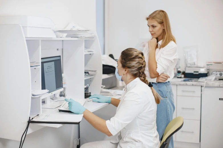 two female staff standing by a work station