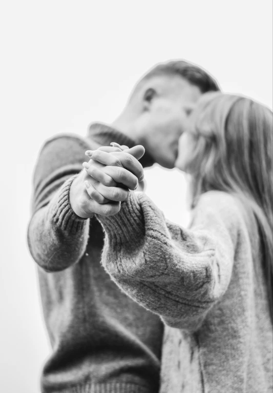 a man and woman kissing with a small object