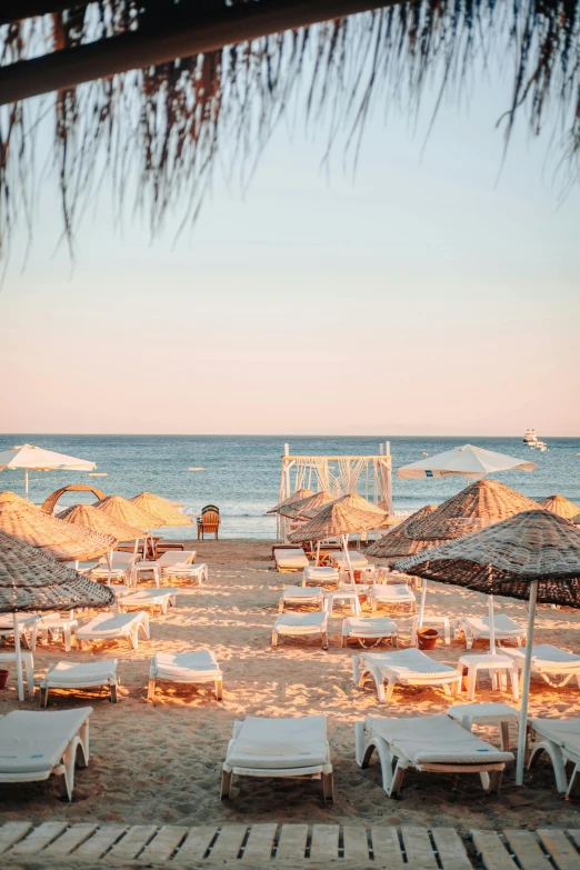 lounge chairs and umbrellas on a beach next to the ocean