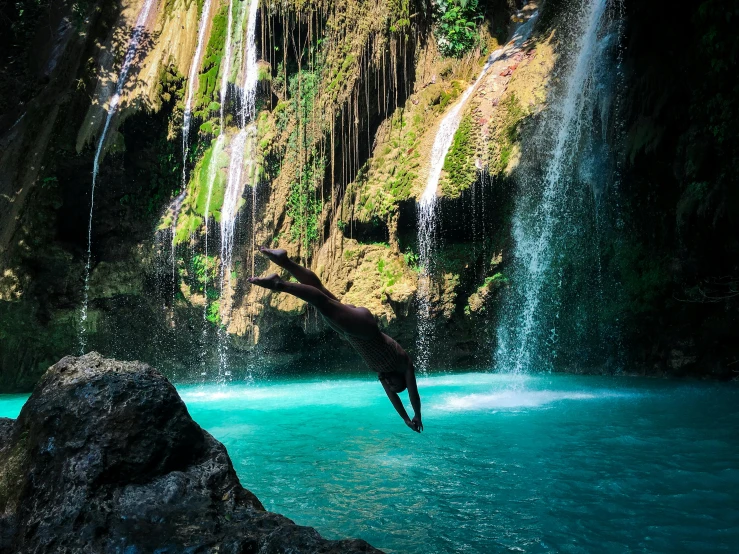 a bird that is flying over a blue body of water