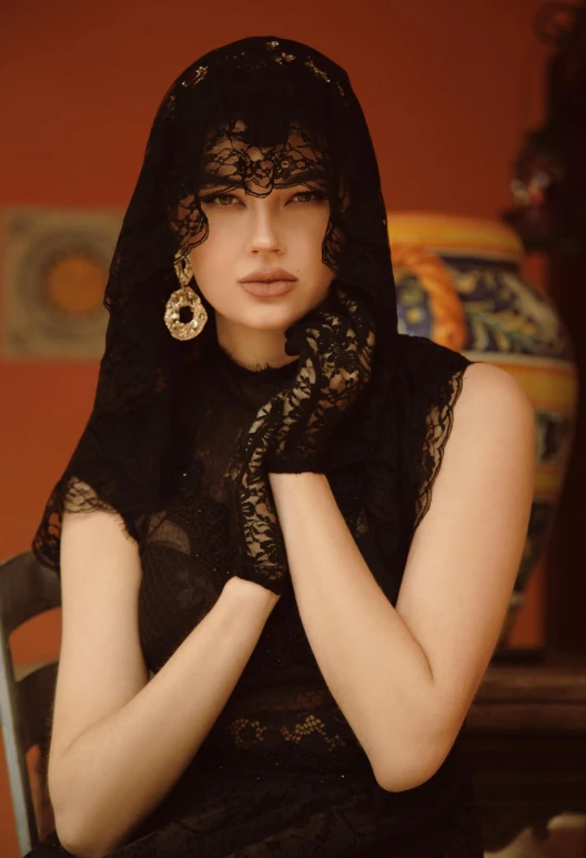 a woman in a black dress and large earrings