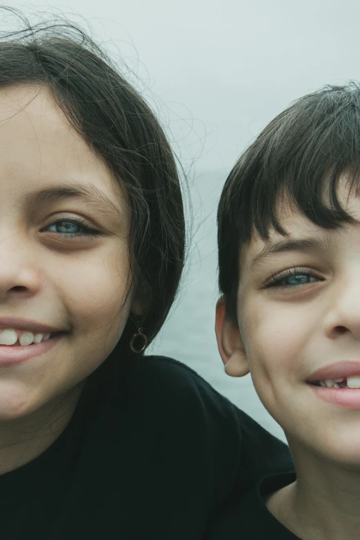 two smiling children one with a toothbrush