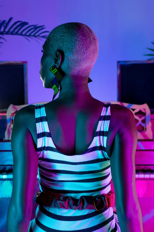 a woman wearing a striped dress in front of colorful lighting