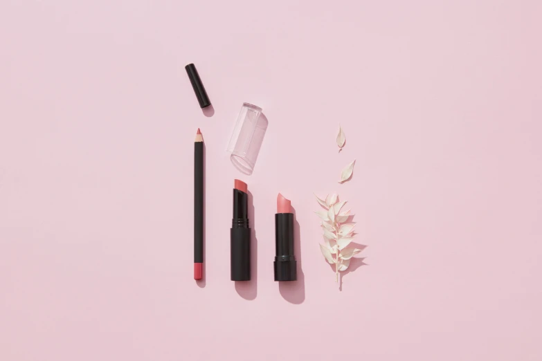 cosmetics and lipstick on a pink background