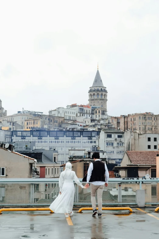 two people are dressed in costume and carrying umbrellas walking on the roof of an apartment building